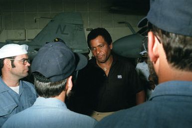 Country singer Charlie Pride visits with crew members aboard the nuclear-powered aircraft carrier USS CARL VINSON (CVN 70). The entertainer is aboard the ship to film a holiday message for the Armed Forces Radio and Television Service