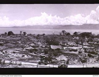 LAE, NEW GUINEA. 1943-10-04. SECTION PHOTOGRAPH OF THE WATERFRONT TAKEN FROM OBSERVATION HILL COVERS MOUNTAIN RANGE, PARSEE POINT, SALAMAUA, AT SEA ON LEFT TO PARTLY RECONSTRUCTED HANGAR ON RIGHT. ..