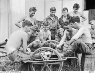 BUKAUA, NEW GUINEA. 1943-10-18. TROOPS OF THE 29/46TH AUSTRALIAN INFANTRY BATTALION PLAYING CARDS OUTSIDE THE MISSION CHURCH. LEFT TO RIGHT: FRONT ROW: VX144156 PRIVATE (PTE) R. STEEL; VX138484 ..