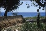 Man standing by thatch canoe covering, Makira