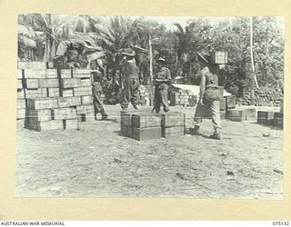 POTSDAM-HANSA BAY AREA, NEW GUINEA. 1944-07-31. PERSONNEL OF THE 241ST SUPPLY DEPOT PLATOON STACKING CASES OF SUPPLIES IN THE UNIT DUMP AT POTSDAM. IDENTIFIED PERSONNEL ARE:- NX120587 CORPORAL G.J. ..