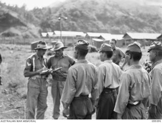 RABAUL, NEW BRITAIN, 1945-12-11. MEMBERS OF THE PROVOST CORPS CHECKING NAMES AND PARTICULARS OF JAPANESE WAR CRIMINALS BEFORE THEIR TRIAL AT HEADQUARTERS 11 DIVISION