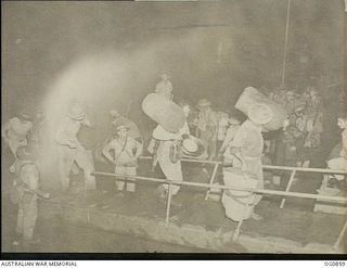 VIVIGANI, GOODENOUGH ISLAND, PAPUA. 1943-11-27. AIRMEN OF NOS. 22 AND 30 SQUADRONS RAAF GOING ABOARD SS HANYANG EARLY IN THE MORNING FOR THE MOVE FROM GOODENOUGH ISLAND TO KIRIWINA IN THE TROBRIAND ..