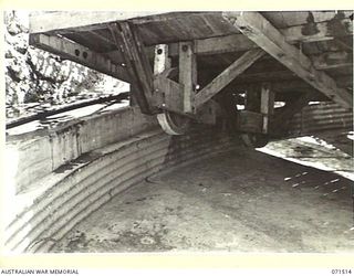 PORT MORESBY, PAPUA, NEW GUINEA. 1944-03-27. THE NO 1 GUN EMPLACEMENT AT BOOTLESS BATTERY COAST ARTILLERY WITH THE LOADING PLATFORM RAISED BY BLOCK AND TACKLE TO SHOW CONSTRUCTION ON THE UNDERSIDE ..