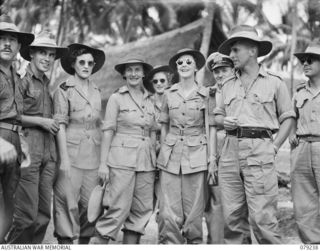 MANGUNUI, JACQUINOT BAY, NEW BRITAIN. 1945-02-25. MEMBERS OF THE AUSTRALIAN ARMY NURSING SERVICE FROM THE 105TH CASUALTY CLEARING STATION WATCHING THE DANCERS DURING A NATIVE SING- SING AT THE ..