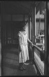 Portrait of woman standing on front porch of building