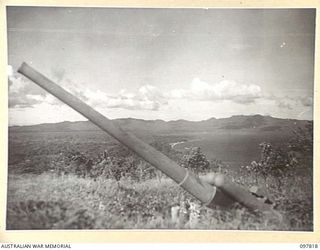 KANGU HILL, BOUGAINVILLE. 1945-10-05. THE BEACH FRONT LOOKING TOWARDS TONELEI HARBOUR. JAPANESE 4-INCH ANTI-AIRCRAFT FUN IN FOREGROUND. THE AREA IS NOW OCCUPIED BY TROOPS OF HEADQUARTERS 2 CORPS