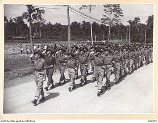 TOROKINA, BOUGAINVILLE. 1945-09-24. TROOPS OF 15 INFANTRY BRIGADE SALUTING AS THEY PASS THE SALUTING BASE DURING THE MARCH PAST AT A PARADE HELD AT GLOUCESTER PARK FOR THE PRESENTATION OF AWARDS. ..