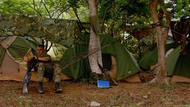US Marine Corps (USMC) Lance Corporal (LCPL) Michael Grimes, 3rd Battalion, 3rd Marines at Marine Corps Air Station (MCAS), Hawaii (HI), his weapon beside him, takes a break at a camp site after a Field Training Exercise (FTX) at Pak Thong Chai, Thailand (THA). This exercise is part of exercise Cobra Gold 2004