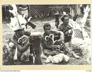 SONG RIVER, FINSCHHAFEN AREA, NEW GUINEA. 1944-03-26. BUKI BOYS PREPARING THEIR COSTUME FOR A NATIVE SING-SING IN THE AUSTRALIAN NEW GUINEA ADMINISTRATIVE UNIT (ANGAU) COMPOUND TO CELEBRATE THE RE ..