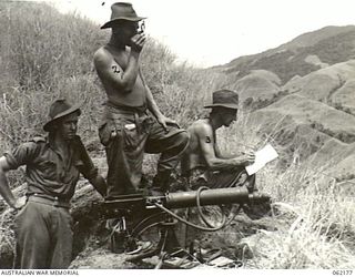 FINISTERRE RANGES, NEW GUINEA. 1943-12-10. TROOPS OF C COMPANY, 2/31ST AUSTRALIAN INFANTRY BATTALION, 25TH AUSTRALIAN INFANTRY BRIGADE, TAKING A COMPASS BEARING AT THE NEW VICKERS GUN POSITION. ..