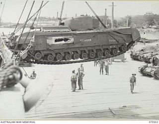 MADANG, NEW GUINEA. 1944-08-23. PERSONNEL OF THE 7TH DOCKS OPERATING COMPANY, UNLOADING A 42 TON CHURCHILL IV TANK FROM THE HOLD OF THE AMERICAN LIBERTY SHIP, NORMAN J. COLMAN. THIS TANK IS ONE OF ..