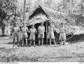 Informal group portrait of Australian naval officers standing outside the naval store office.  Identified left to right: unidentified; Lieutenant (Lt) Ritchie; Lt Frank Edward Grace; Lt Samuel ..