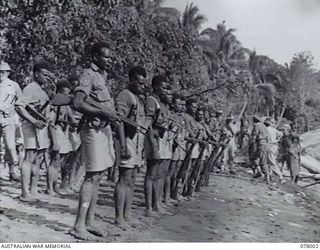 SAMPUN, NEW BRITAIN. 27 DECEMBER 1944. NATIVE TROOPS OF THE ALLIED INTELLIGENCE BUREAU DRAWN UP ON THE BEACH TO FORM A GUARD OF HONOUR FOR THE GENERAL OFFICER COMMANDING 5 DIVISION DURING HIS VISIT ..