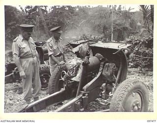 VUNAPOPE MISSION, RABAUL AREA, NEW BRITAIN. 1945-09-28. LIEUTENANT GENERAL J. NORTHCOTT, CHIEF OF GENERAL STAFF, INSPECTING AN AUSTRALIAN 4.5 INCH HOWITZER, ONE OF THE WEAPONS IN A JAPANESE DUMP ..