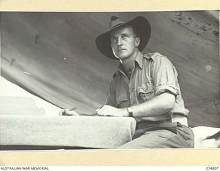 MILILAT, NEW GUINEA. 1944-07-16. QX45377 WARRANT OFFICER I, A. ALLISON, REGIMENTAL SERGEANT MAJOR, HEADQUARTERS SIGNALS, 5TH DIVISION, WORKING IN HIS TENT OFFICE
