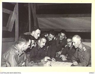 TOL PLANTATION, NEW BRITAIN, 1945-08-02. AN AUSTRALIAN ARMY SERVICE CORP CONFERENCE ON SUPPLIES AT HEADQUARTERS AUSTRALIAN ARMY SERVICE CORP, 13 INFANTRY BRIGADE. IDENTIFIED PERSONNEL ARE:- CAPTAIN ..