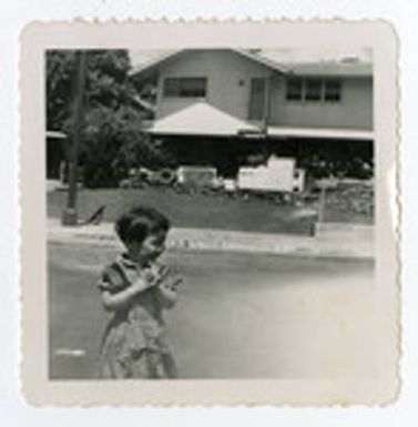 Young girl standing in front of house
