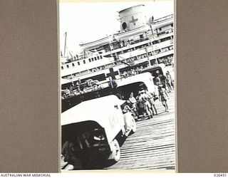 PORT MORESBY, PAPUA. 1942-08. MOTOR AMBULANCES ON THE WHARF AT PORT MORESBY, CARRYING AUSTRALIANS WOUNDED IN ACTION AGAINST THE JAPANESE, WAITING TO UNLOAD THEIR PATIENTS ON TO THE HOSPITAL SHIP ..