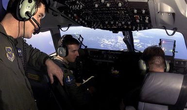 United States Air Force Captain Mike Wollet, left, Captain Jay Clark, center, Major Dean Steele, fly a C-17 Globemaster aircraft loaded with humanitarian earthquake relief cargo bound for India