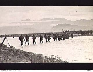 UMI RIVER, NEW GUINEA. 1943-09-29. TROOPS OF THE 2/27TH AUSTRALIAN INFANTRY BATTALION WADING ACROSS THE RIVER WITH THE AID OF A ROPE