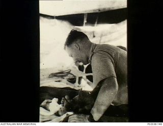 Port Moresby, Papua. 1942-12. A medical officer examining a patient's foot after a surgical operation at No. 5 Casualty Clearing Station. (Original housed in AWM Archive Store)