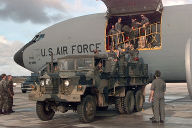 Members of the 200th and 201st Red Horse Air National Guard, Rickenbacker Air National Guard Base, Columbus, Ohio, unload their equipment at Andersen Air Force Base, Guam. They are deployed to help in the housing relief effort after Super Typhoon Paka