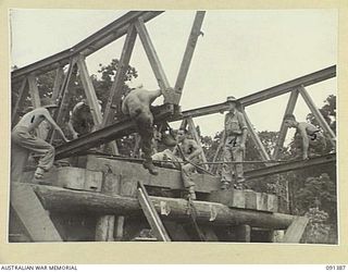 BOUGAINVILLE. 1945-05-01. SAPPERS OF 15 FIELD COMPANY, ROYAL AUSTRALIAN ENGINEERS, ASSEMBLING THE APPROACHES TO A NEW AUSTPANEL BRIDGE ACROSS THE PURIATA RIVER. THIS AUSTRALIAN MADE BRIDGE, USED IN ..