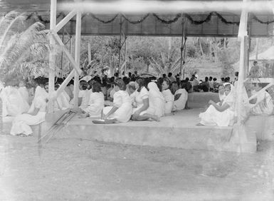 [A large group of pacific island people in an open air pavilion]