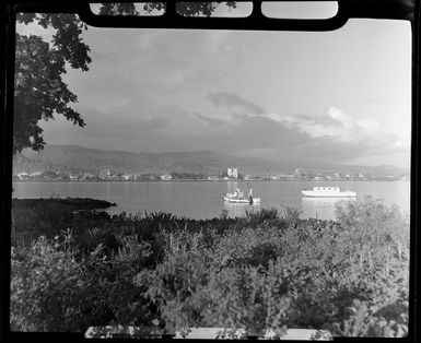 Apia waterfront, Upolu, Samoa, showing two boats in the lagoon and buildings in the background