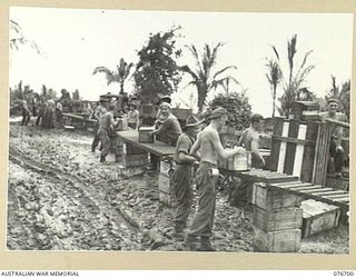 JACQUINOT BAY, NEW BRITAIN. 1944-11-06. TROOPS OF THE 6TH INFANTRY BRIGADE USING ROLLERS TO GET STORES AND SUPPLIES INLAND FROM THE UNIT BRIDGEHEAD