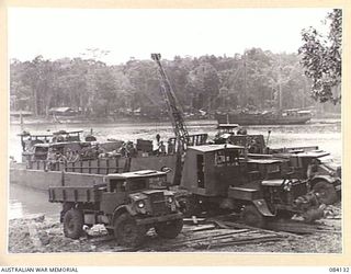 WUNUNG PLANTATION, JACQUINOT BAY, NEW BRITAIN. 1944-12-08. A BUSY SCENE AT BONDI BEACHHEAD, (NO. 20) AS A CRANE ALONGSIDE 14/32 INFANTRY BATTALION TROOPS UNLOADS STORES