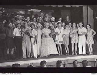 THORPEVILLE, NEW GUINEA. 1943-06-29. FULL COMPANY OF THORP'S TROOPERS, INCLUDING PROPERTY MEN, CURTAIN MEN, SPOTLIGHT MAN AND SOUND EFFECTS MAN, TAKEN ON THE STAGE OF THE NEWLY BUILT THEATRE. ..