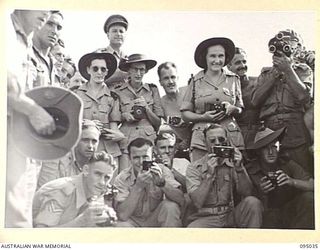 TOROKINA, BOUGAINVILLE, 1945-08-15. A BATTERY OF CAMERAS GREETING THE BRIDE AND GROOM OUTSIDE THE CHAPEL, 2/1 GENERAL HOSPITAL, AFTER THE MARRIAGE OF PTE E.M. TOWNSEND AND CPL J.H. RICKARD. THE ..