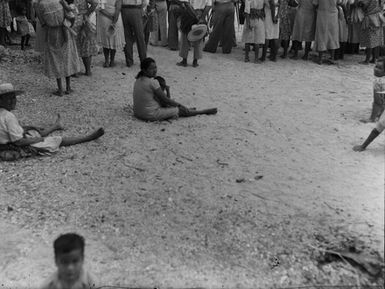 [Portrait of a Pacific island woman and child sitting on the ground]