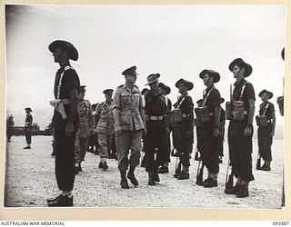 JACQUINOT BAY, NEW BRITAIN. 1945-07-01. HIS ROYAL HIGHNESS, THE DUKE OF GLOUCESTER, GOVERNOR-GENERAL OF AUSTRALIA (4), ACCOMPANIED BY MEMBERS OF THE OFFICIAL PARTY INSPECTING THE GUARD OF HONOUR ..