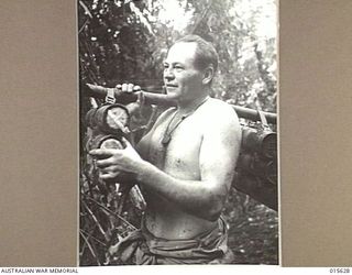 1943-08-30. NEW GUINEA. SGT. CHARLES ROBERTSON OF SOUTH YARRA, VIC., CARRYING MORTAR BOMBS NEAR MOUNT TAMBU. MORTARS WERE EXTENSIVELY USED BY BOTH SIDES IN THE BITTER FIGHTING HERE. (NEGATIVE BY H. ..