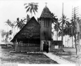 MADANG, NEW GUINEA. 1944-12-19. FRONT VIEW OF THE RAAF MEMORIAL CHAPEL AT THE FORWARD RAAF BASE SHOWING THE CORAL PATH IN FORM OF A CROSS AND SPIRE. THE COMMAND CHURCH OF ENGLAND CHAPLAIN RUSSELL ..