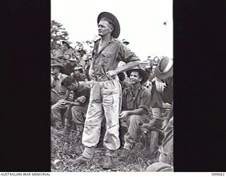 LAE, NEW GUINEA, 1946-01-28. PRIVATE J. CANTWELL, FORMERLY OF 2/1ST COMMANDO SQUADRON QUESTIONING THE HONOURABLE F. M. FORDE, MINISTER FOR THE ARMY, AT THE CONCLUSION OF HIS ADDRESS TO SERVICE ..
