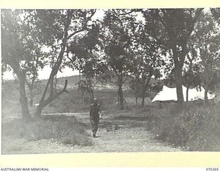 DUMPU, RAMU VALLEY, NEW GUINEA, 1944-02-03. TX1716 SERGEANT F.R. MUSSON, OF THE MILITARY HISTORY SECTION ATTACHED TO THE NEW GUINEA FORCE HEADQUARTERS, PICTURED TO THE LEFT OF THE CHURCH OF ENGLAND ..