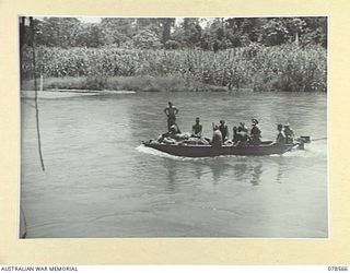BOUGAINVILLE AREA. 1945-01-22. TROOPS OF THE 2/8TH COMMANDO SQUADRON PROCEEDING UP THE JABA RIVER IN THEIR FLAT BOTTOMED BARGE DRIVEN BY AN OUTBOARD MOTOR