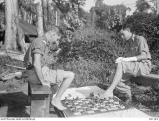 BOUGAINVILLE. 1945-04-26. PRIVATE C.D. MILLS, 61 INFANTRY BATTALION (1), PLAYING DRAUGHTS WITH SERGEANT W.J. KINNINMONT, 9 INFANTRY BATTALION (2). THE MEN, PATIENTS AT 2/3 CONVALESCENT DEPOT, USE ..