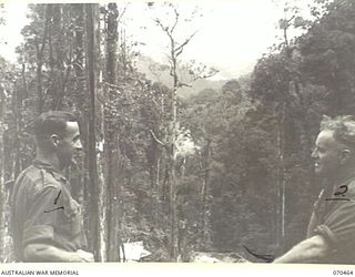 RYAN'S POST, FINISTERRE RANGE, NEW GUINEA, 1944-02-15. NX78344 SERGEANT S.G. ARMSTRONG (1), AND Q2722486 SERGEANT S. BRYAN (2), MEMBERS OF THE AUSTRALIAN NEW GUINEA ADMINISTRATIVE UNIT, VIEW THE ..