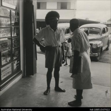 Men speaking outside of a shop