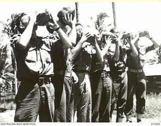 MILNE BAY, NEW GUINEA. 1944-04-06. PERSONNEL AT 53RD DEPUTY COMMANDER, ROYAL AUSTRALIAN ENGINEERS DRINKING COCONUT MILK, A FAVOURITE BEVERAGE WITH TROOPS IN THE AREA. IDENTIFIED PERSONNEL ARE:- ..