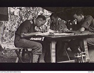 NADZAB AREA, NEW GUINEA. 1943-09-20. INTELLIGENCE SECTION STAFF OF HEADQUARTERS, 7TH AUSTRALIAN DIVISION. LEFT TO RIGHT: SX8690 CAPTAIN A. H. MCLAY, INTELLIGENCE OFFICER; NX89953 CORPORAL N. E. ..