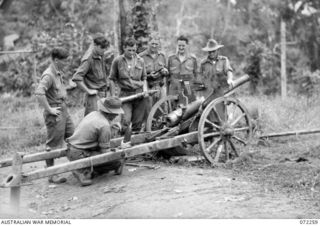 DUMPU, NEW GUINEA. 1944-04-03. MEMBERS OF THE 57/60TH INFANTRY BATTALION EXAMINING A MOUNTAIN GUN ABANDONED BY THE JAPANESE IN THEIR RETREAT ALONG THE BOGADJIM ROAD. IDENTIFIED PERSONNEL ARE:- ..