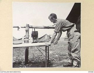 CAPE WOM, WEWAK AREA, NEW GUINEA. 1945-08-28. SERGEANT J.D. HATCH, 104 CASUALTY CLEARING STATION CLEANING SLIDES IN THE RESEARCH DEPARTMENT