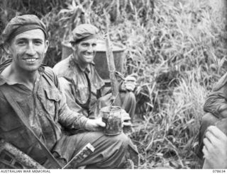 BOUGAINVILLE ISLAND. 1945-01-18. NX17238 LIEUTENANT G.R. MCGAULY (1) AND VX78172 GUNNER W. WEBB (2) OF THE 2ND FIELD REGIMENT, ENJOYING A CUP OF TEA ON THEIR RETURN TO CAMP AFTER A 9 DAY PATROL ..