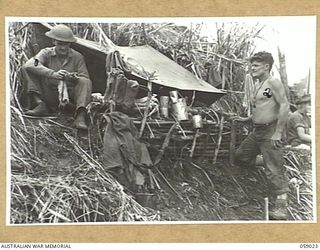 FARIA VALLEY, NEW GUINEA, 1943-10-17. TROOPS OF THE 2/16TH AUSTRALIAN INFANTRY BATTALION, CAMPED NEAR THE TOP OF JOHN'S KNOLL. SHOWN ARE:- QX19644 LIEUTENANT R.E. BUCHANAN (LEFT), A COMPANY, AND ..